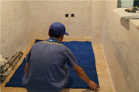 櫥柜安裝師傅在安裝前鋪地毯保護客戶(hù)家的地板