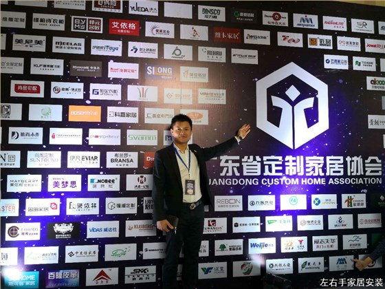 左右手家居安裝創(chuàng  )始人盧建華先生在2018廣州定制家具峰會(huì )會(huì )員企業(yè)名單墻拍照留念