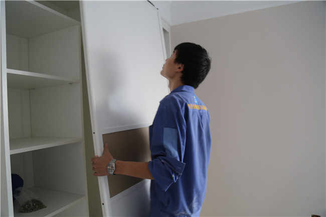 家具安裝工正在現場(chǎng)進(jìn)行衣柜維修工作