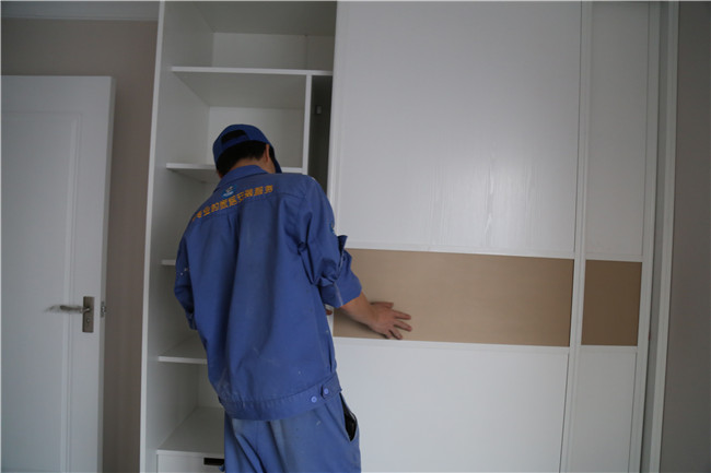 家具安裝工正在調整衣柜門(mén)